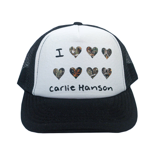 A black and white mesh I Love CH - Black/White Trucker Hat with camouflage hearts and "Carlie Hanson" printed on the front.